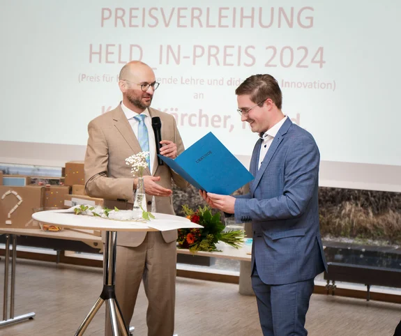 Foto v.l. Rektor Prof. Dr. Kim-Patrick Sabla-Dimitrov überreicht Kevin Kärcher den HELD_IN Preis 2024