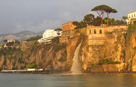 Foto zeigt eine Stadt, erhoben auf einer Meeresküste im Abendrot
